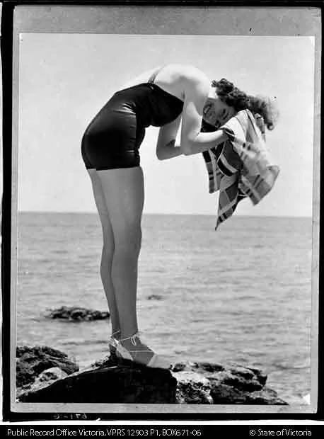 BETTERMENT BOARD PHOTOS WOMAN DRYING HAIR WEARING SWIMSUIT