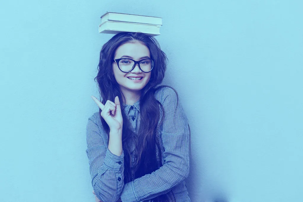 Young asian woman with books on head