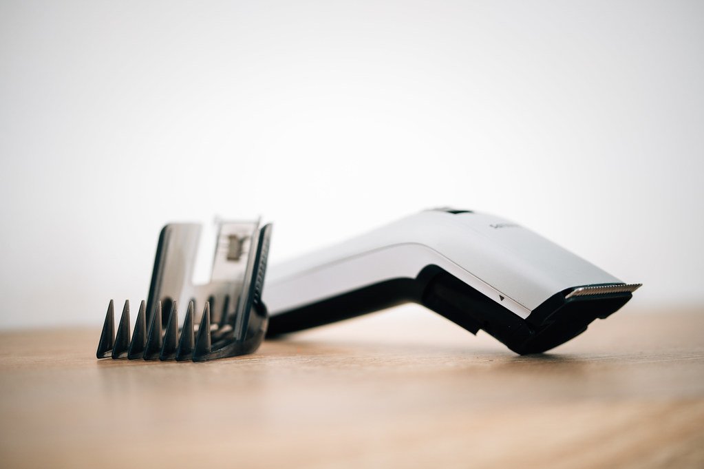 Close-up of a hair clipper next to an attachable comb