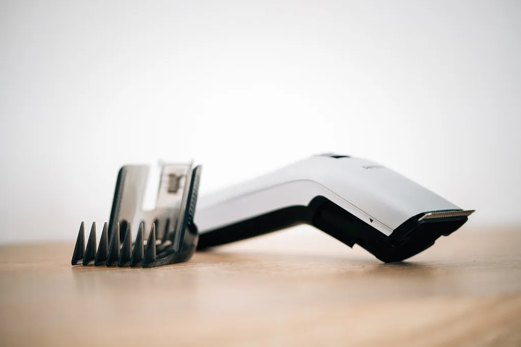 Close-up of a hair clipper next to an attachable comb