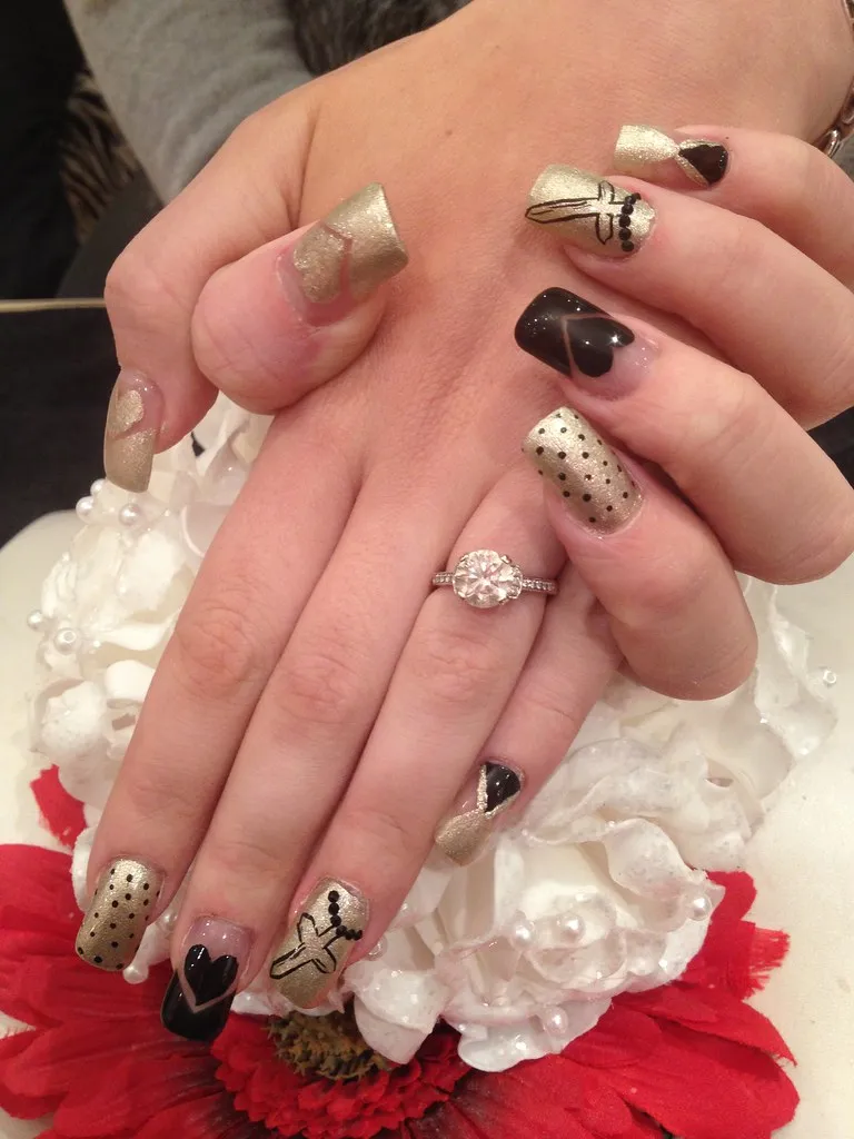 Acrylic nails with black and gold nail art