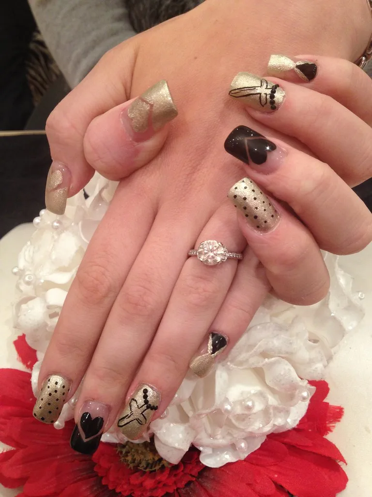 Acrylic nails with black and gold nail art