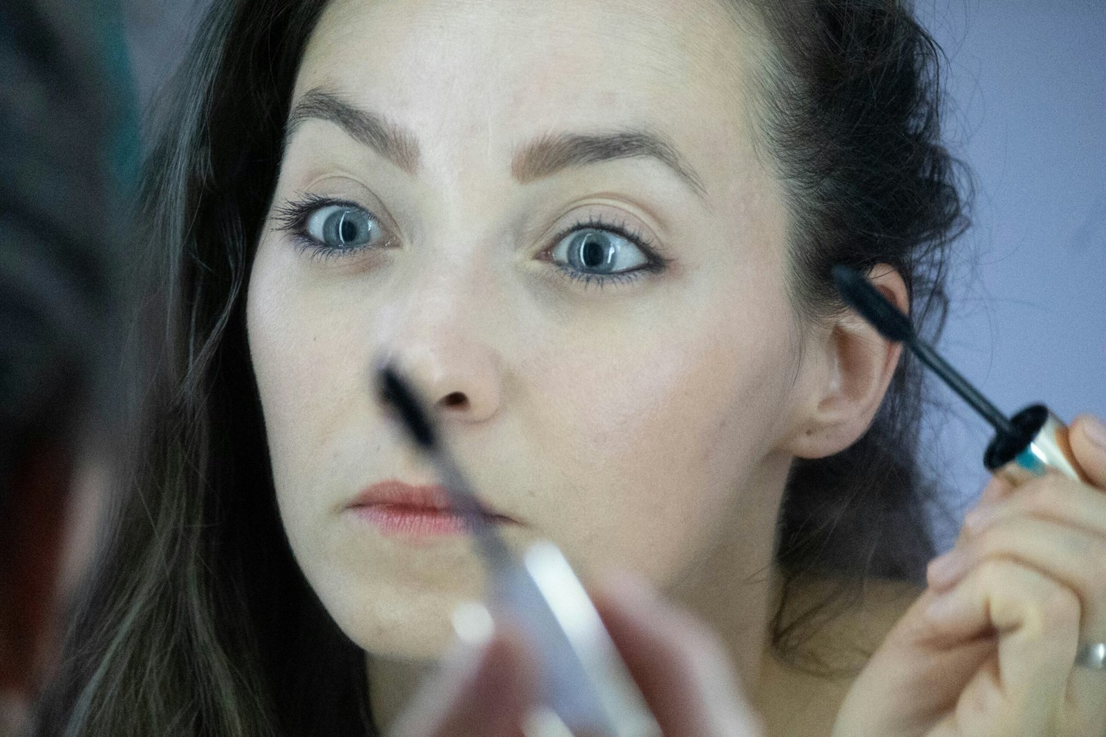 a woman is doing makeup on her face