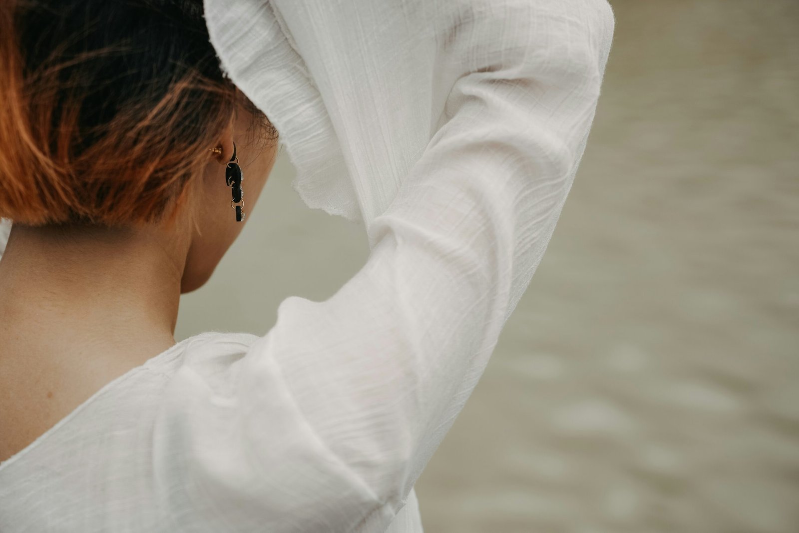 a woman with red hair is wearing a white shirt
