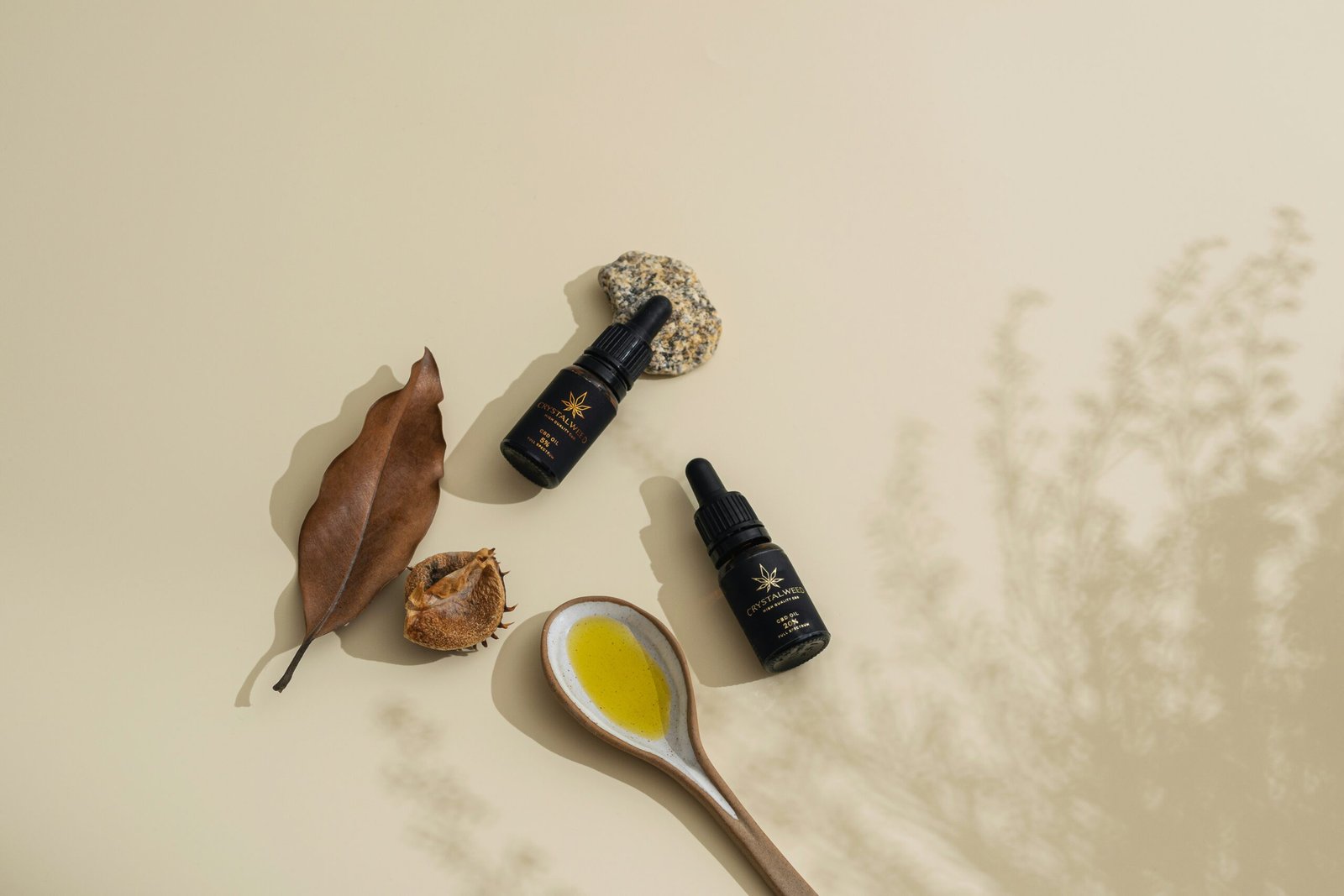 a spoon with a yellow liquid next to some leaves