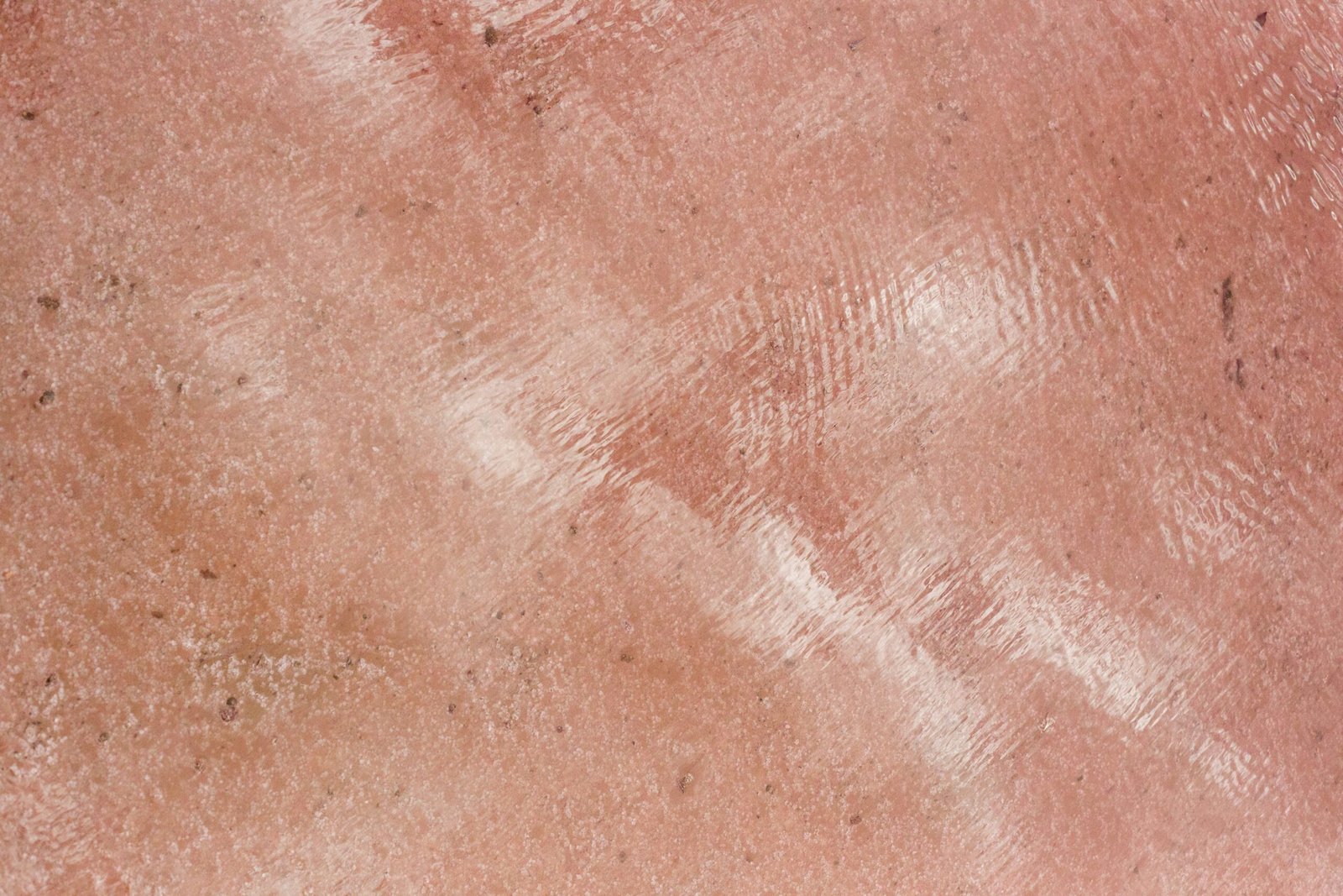 Textured pink surface with a reflective shine.