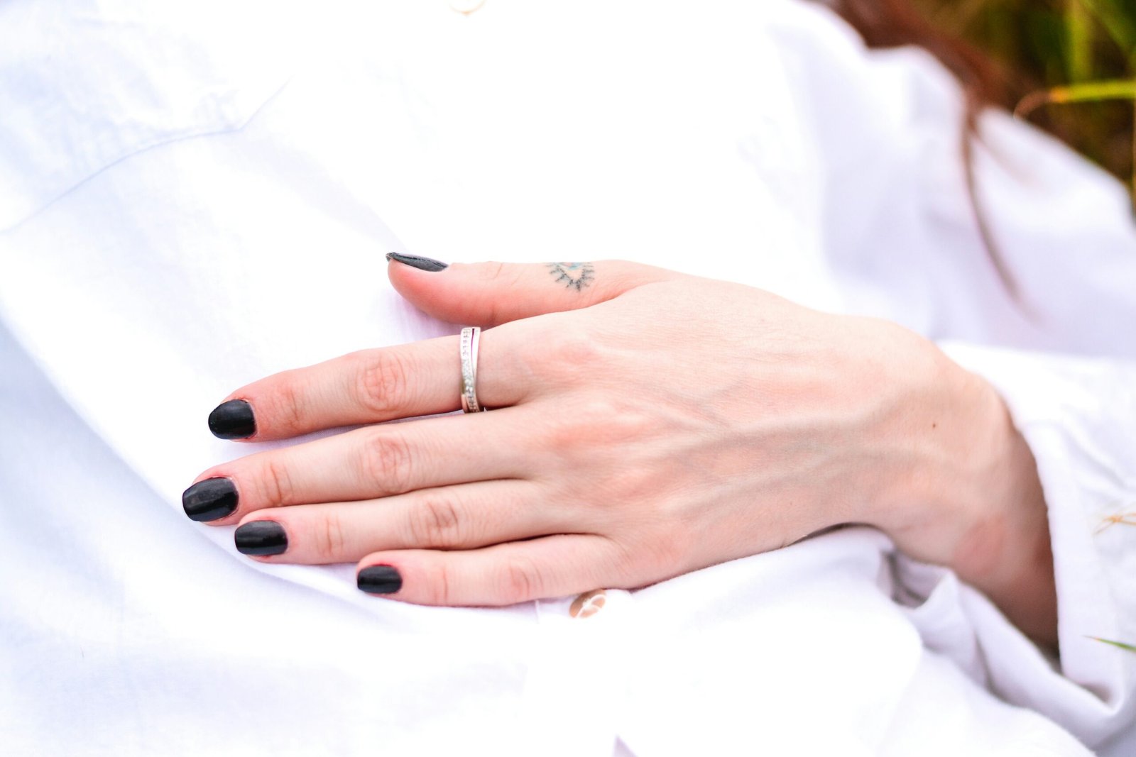 a woman's hand with black nails