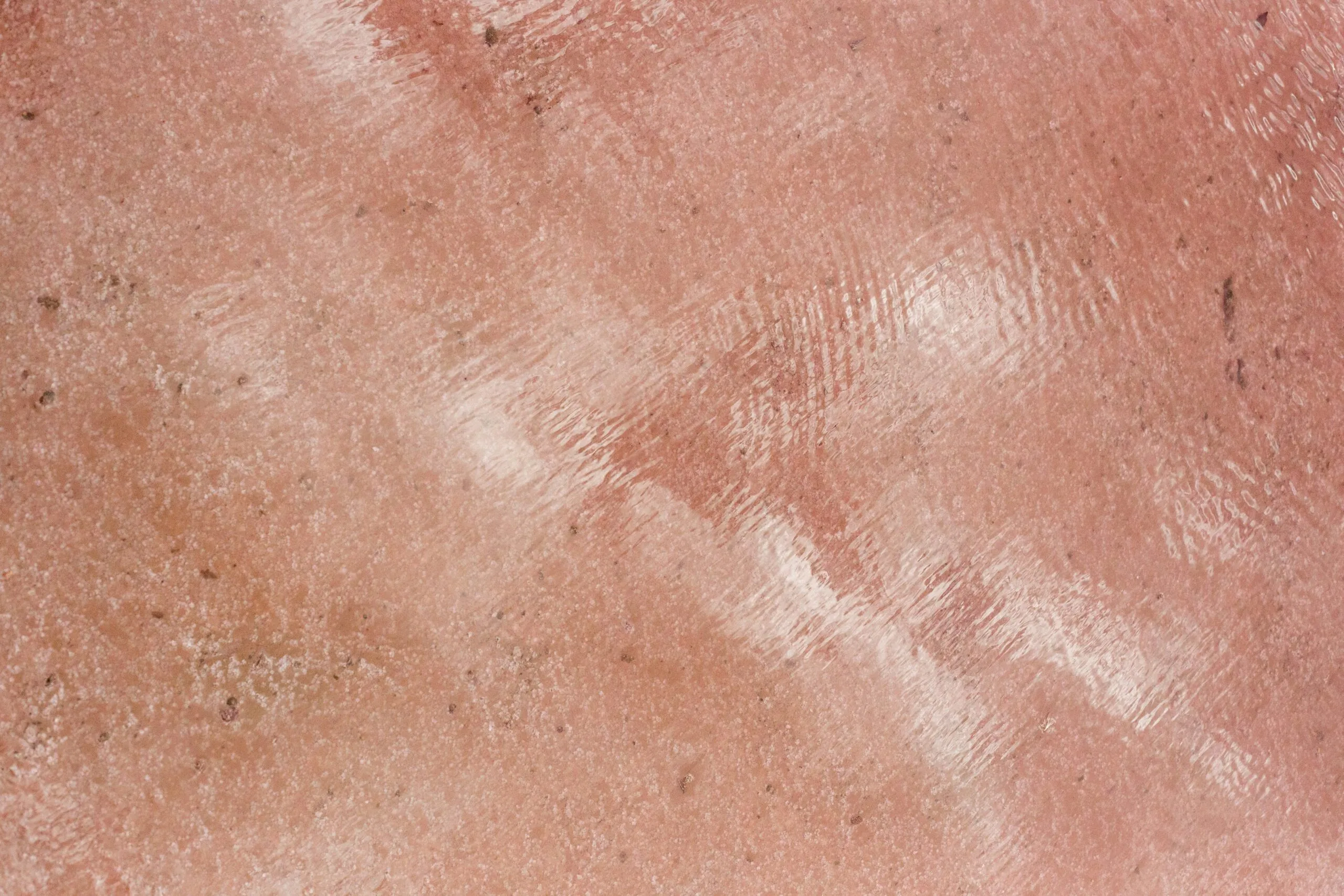 Textured pink surface with a reflective shine.