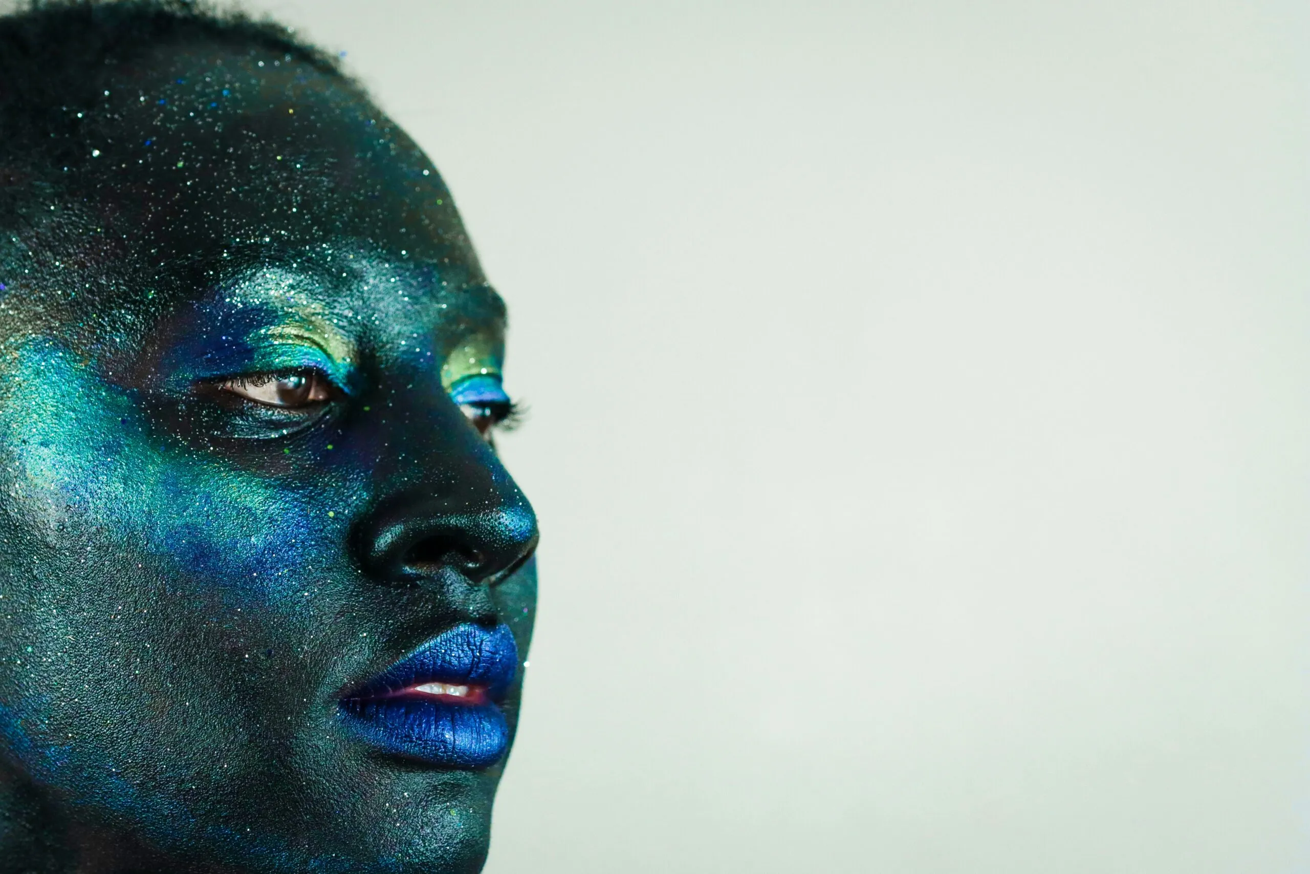 A person with dark blue and green face paint.