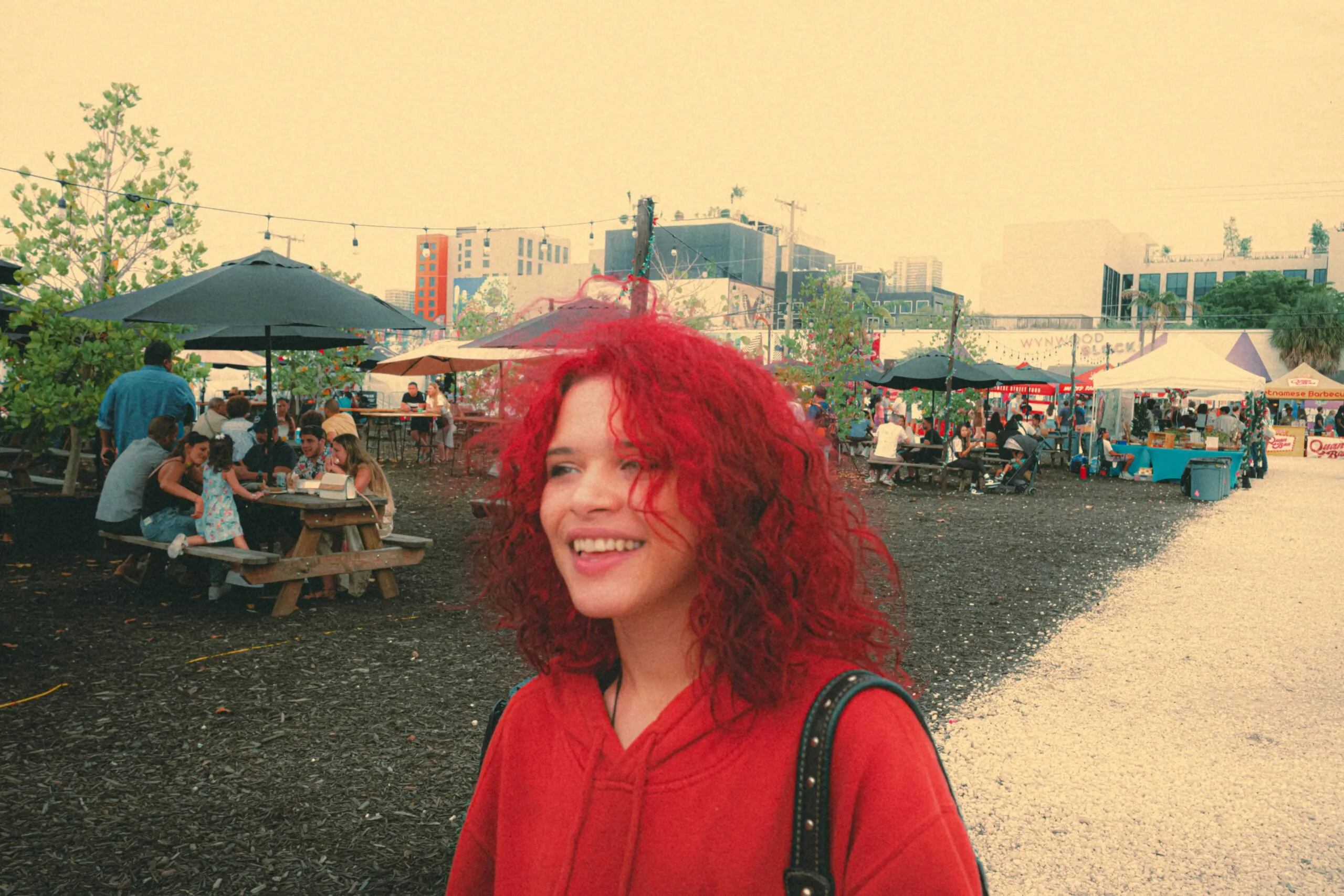 a woman with red hair standing in a park
