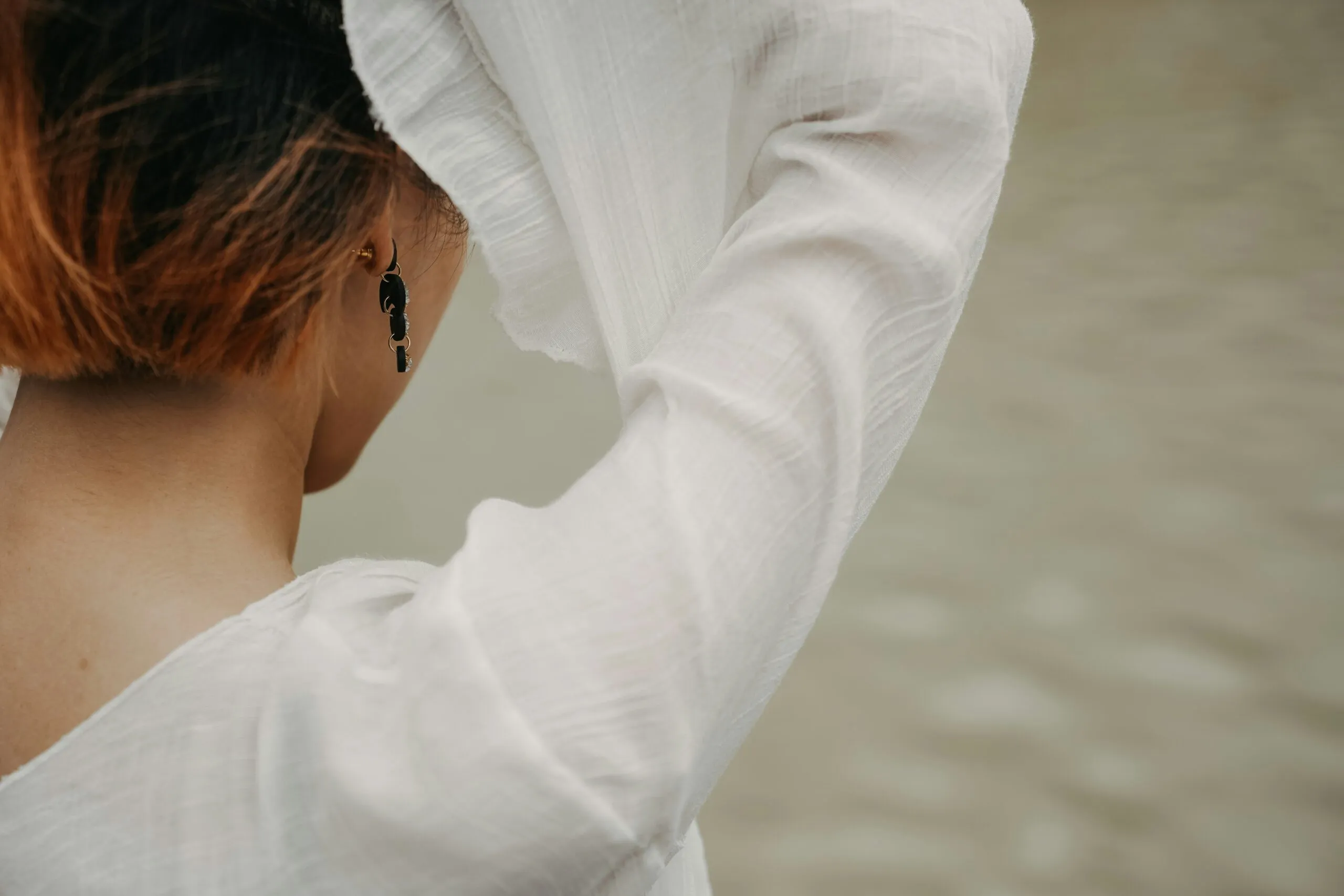 a woman with red hair is wearing a white shirt