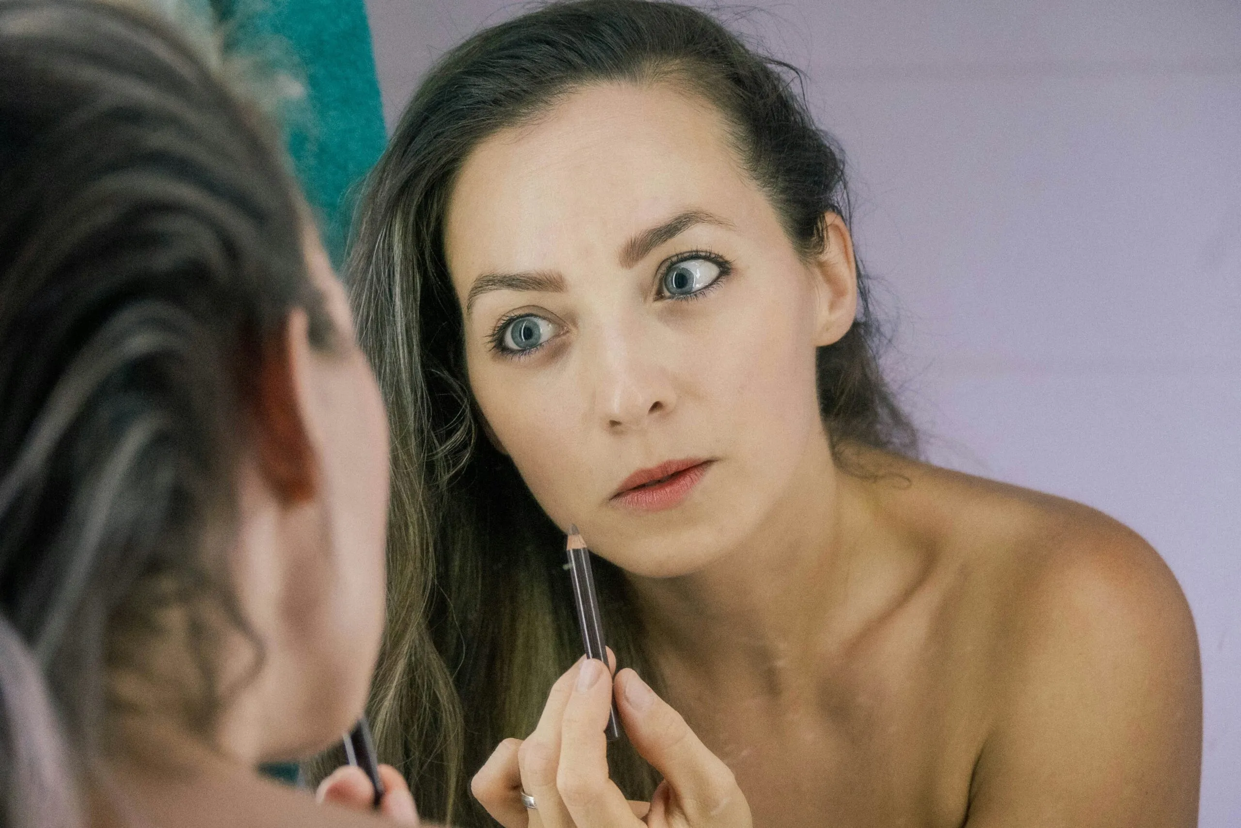 a woman is looking at her reflection in the mirror