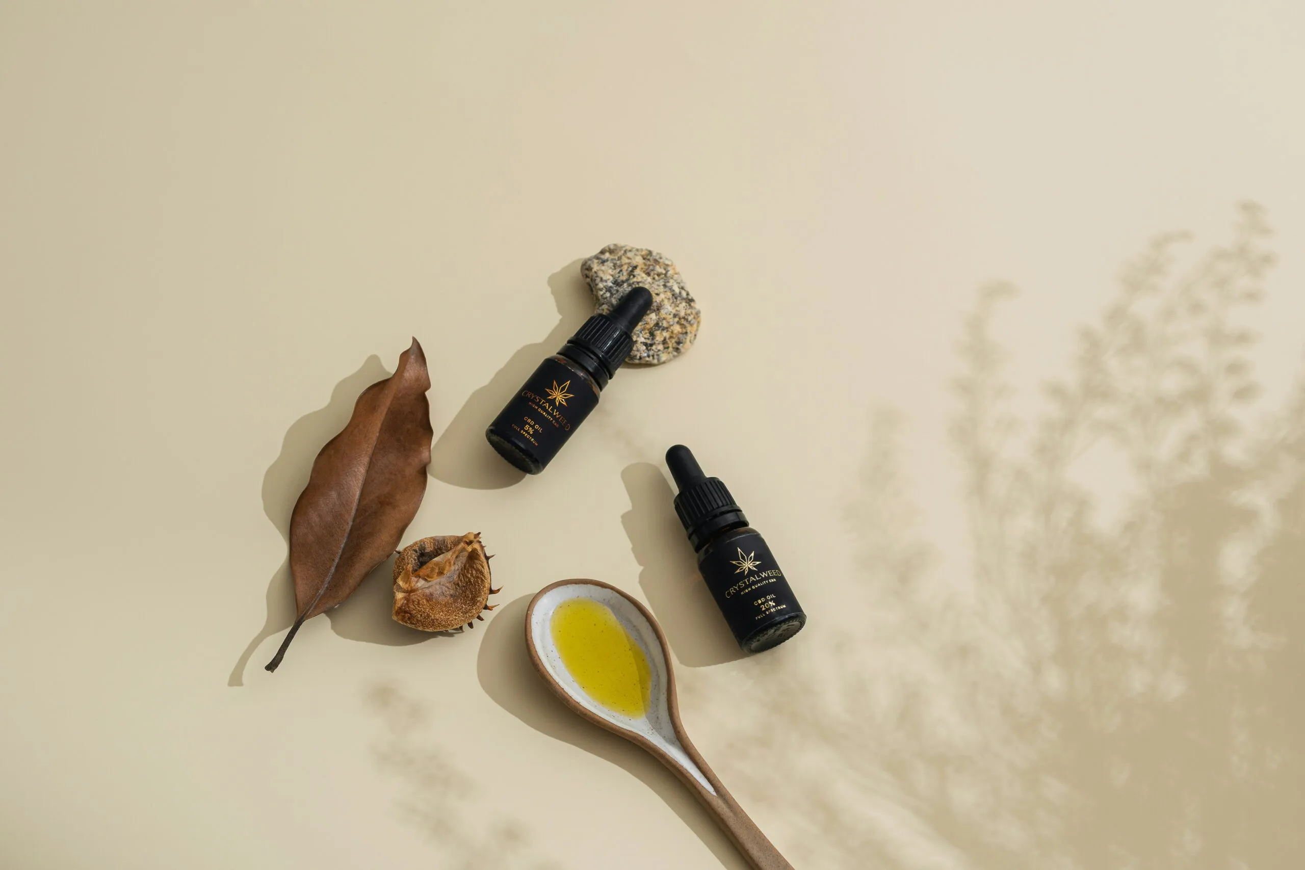 a spoon with a yellow liquid next to some leaves