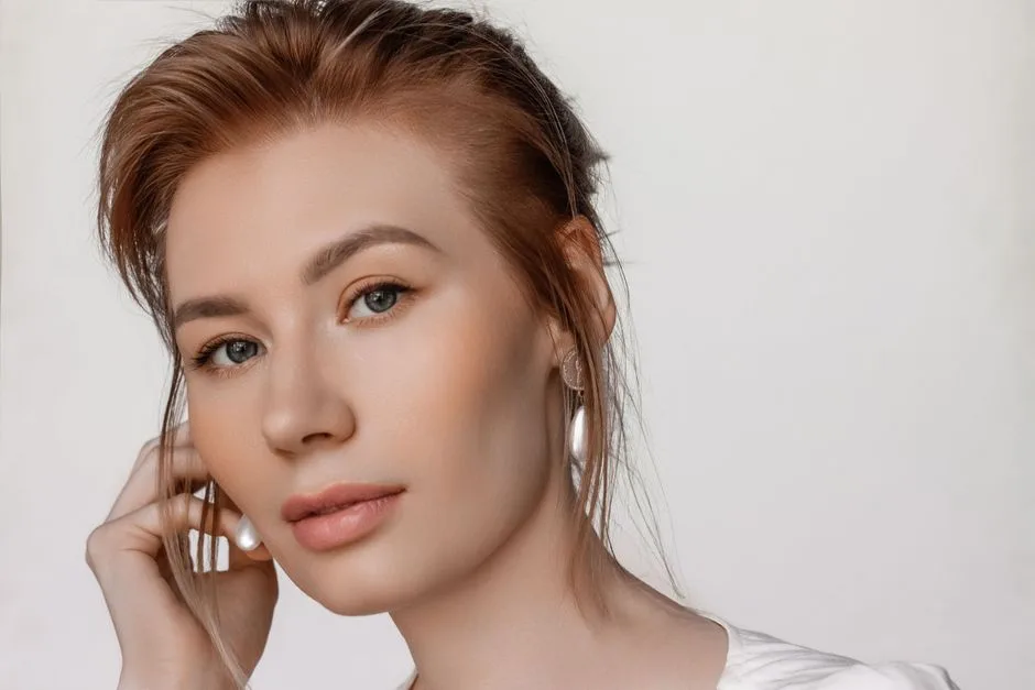 Elegant studio portrait of a young woman with clean makeup and earrings, taken in Moscow.