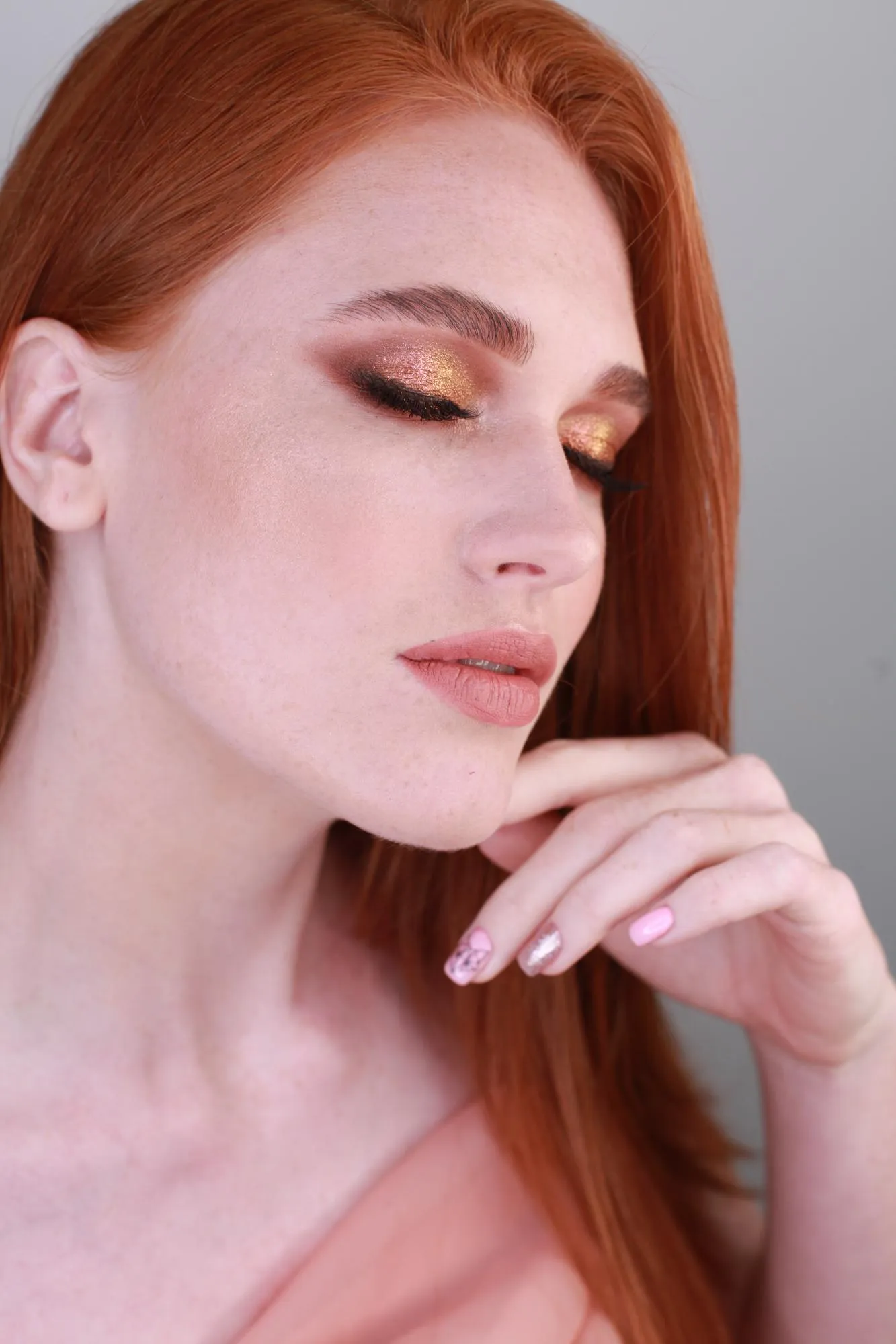 Close-up of beautiful woman with eyes closed against gray background