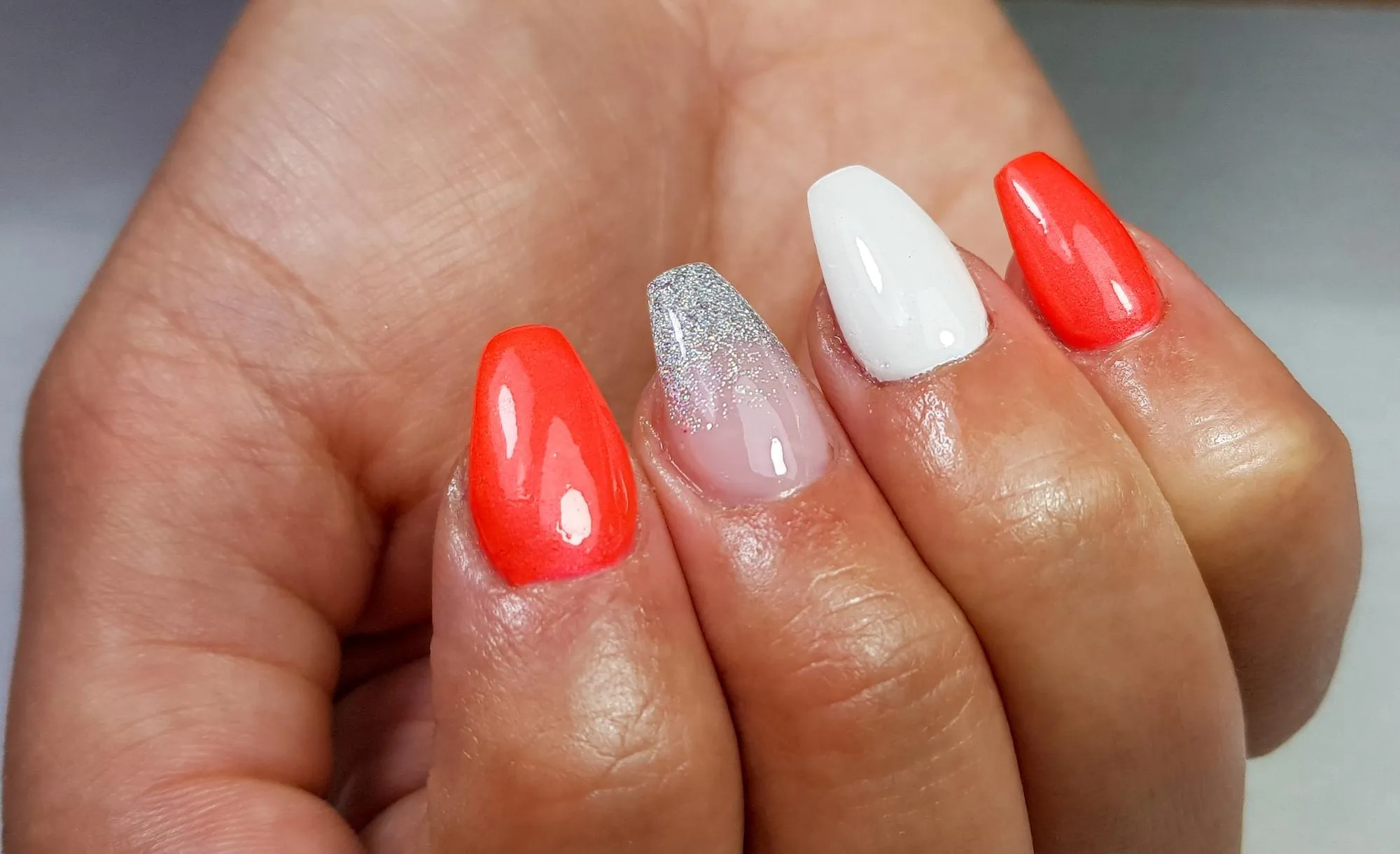 Closeup of a colorful manicure on coffinshaped nails under the lights