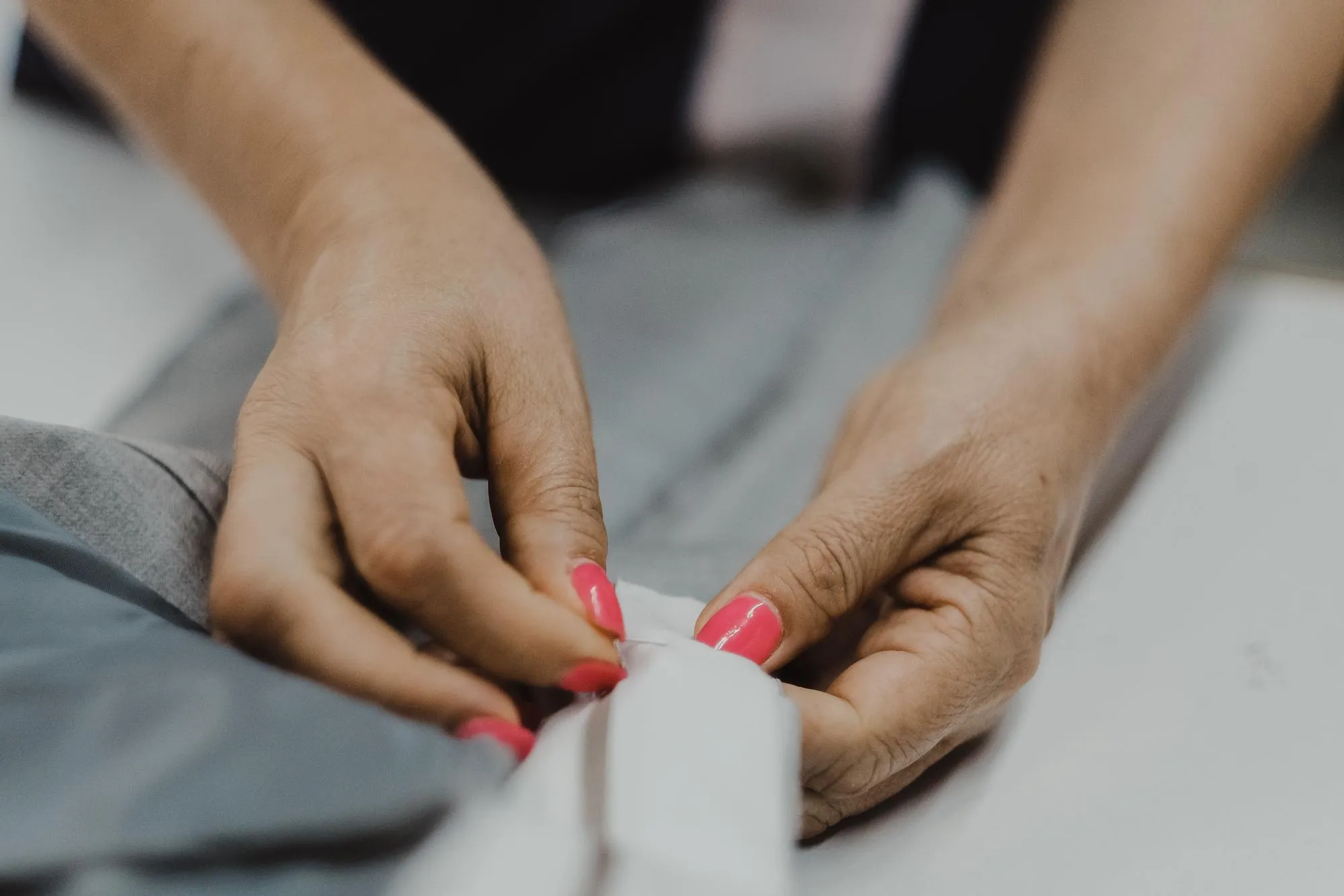 Closeup shot of female hands sewing with a needle