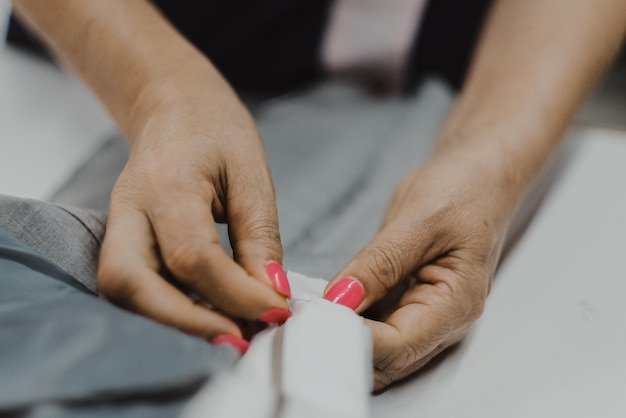 Closeup shot of female hands sewing with a needle