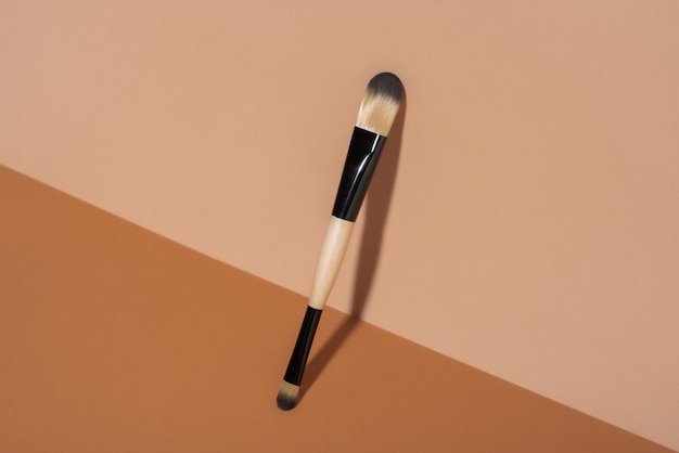 Cosmetic brush on a beige background