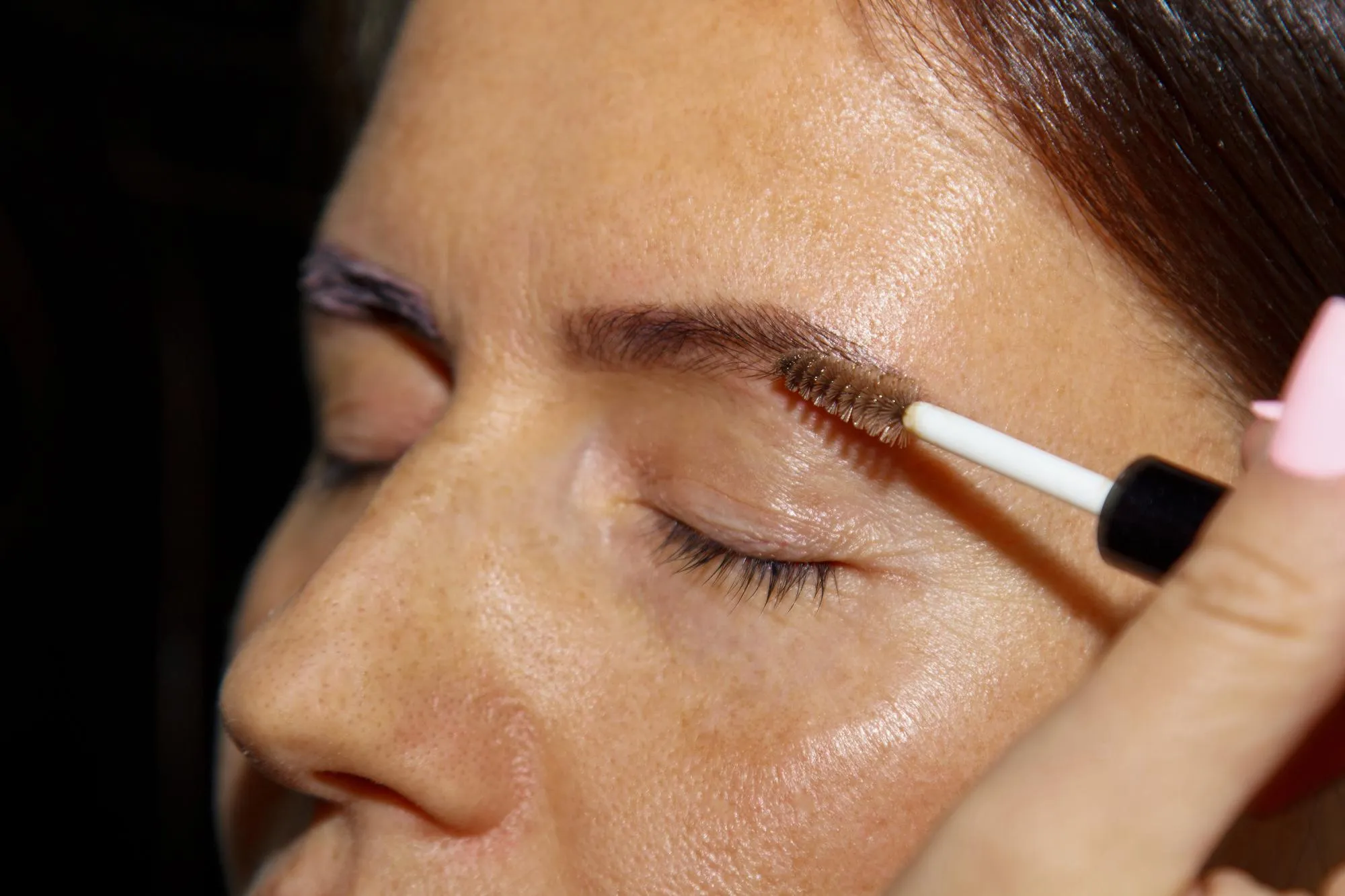 cosmetologist makeup artist paints henna on previously plucked design trimmed eyebrows in a beauty salon in a correction session Professional facial