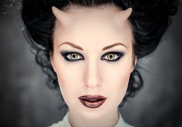 Digital composite image of horned young woman with make-up