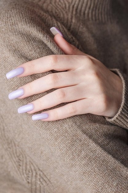 Girl's hands with a soft purple manicure