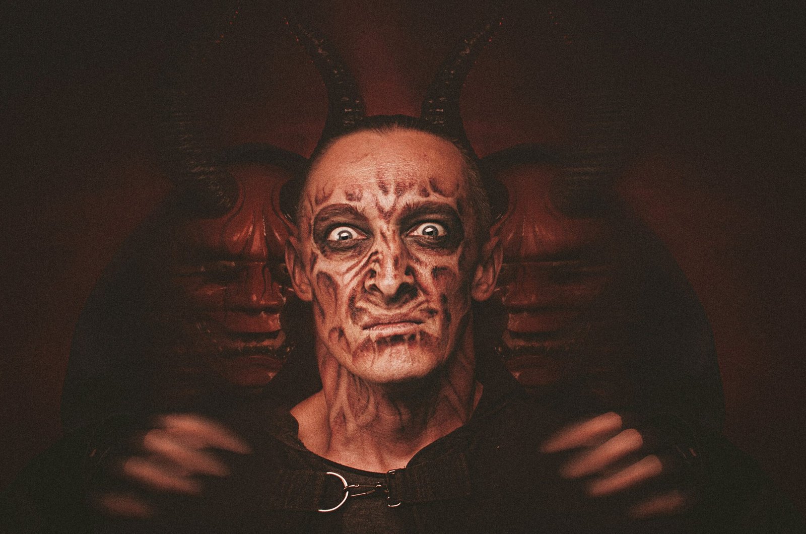 a man with a devilish face and horns on his head