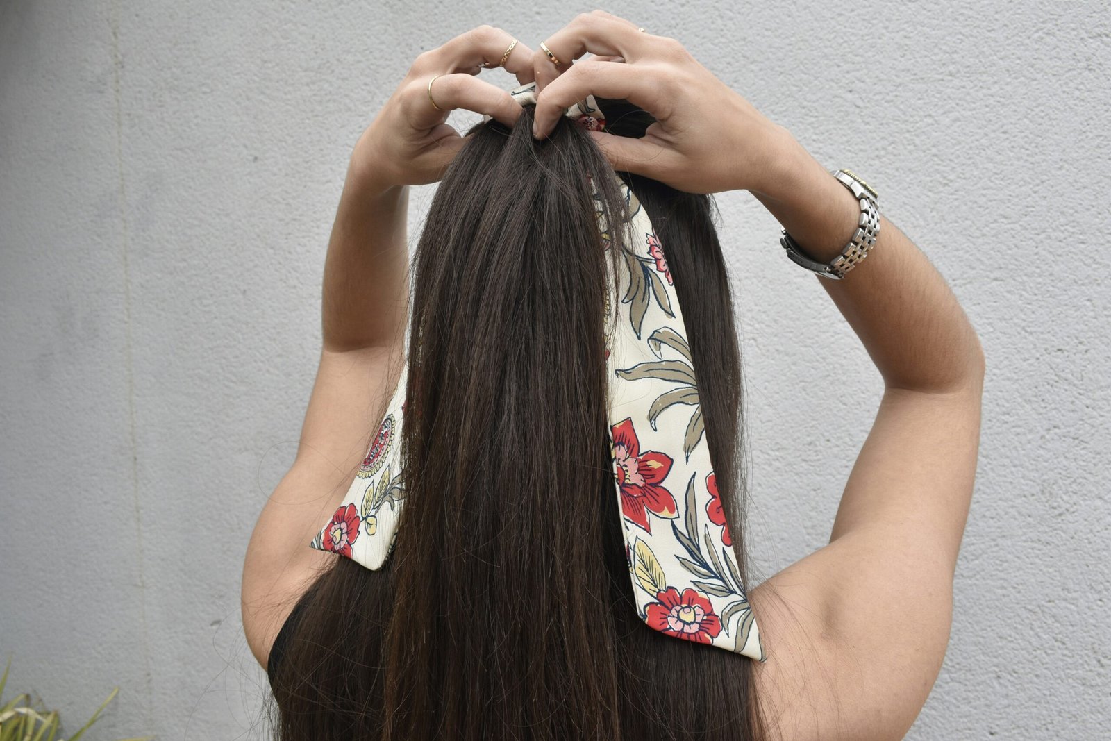 a woman with long hair is putting on a bandana