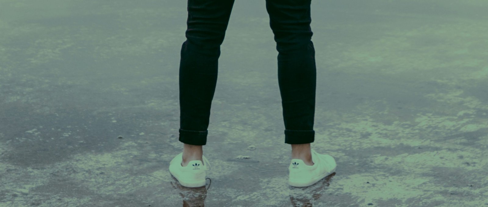 man wearing white sneakers and black pants