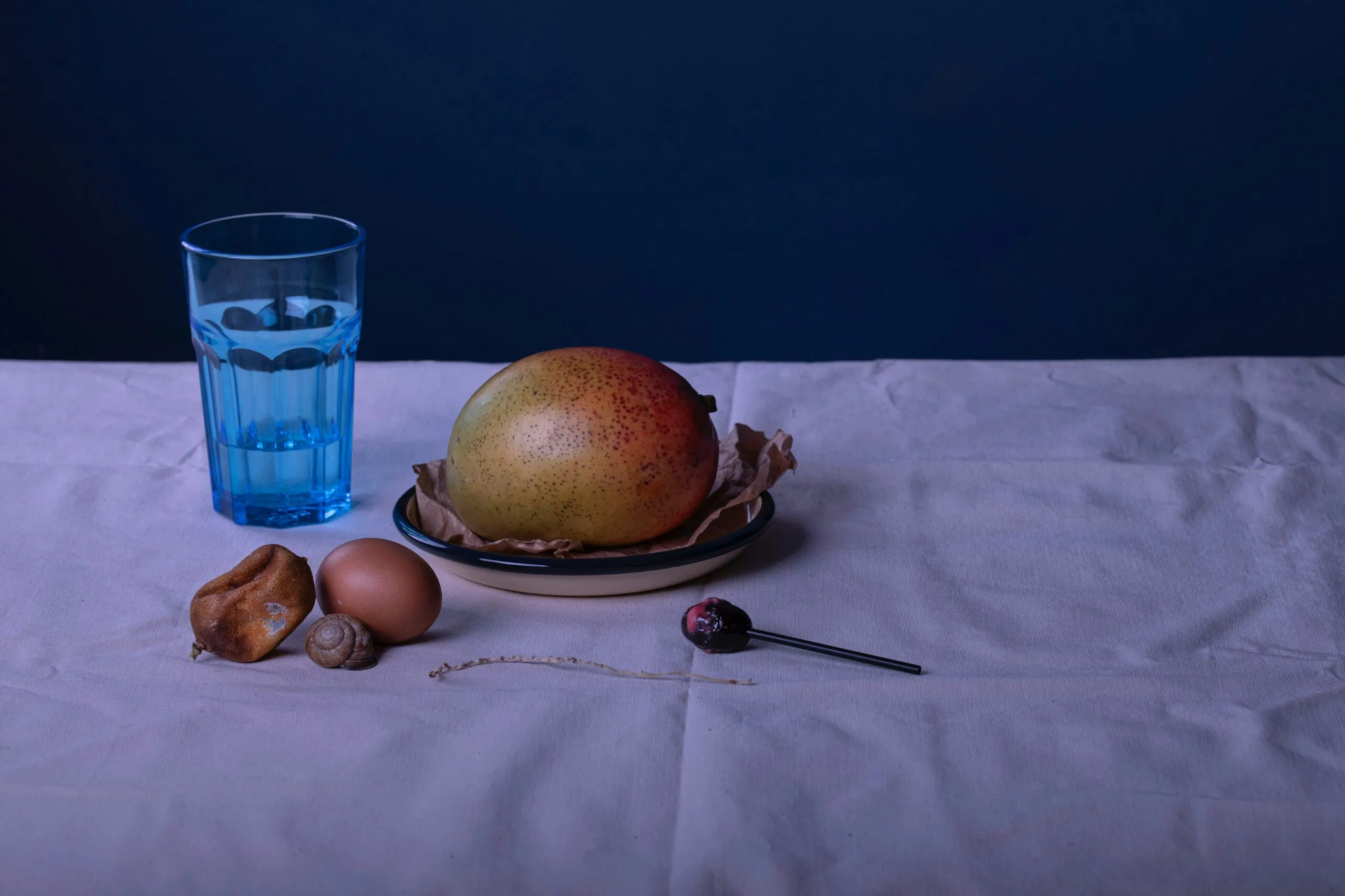 a table topped with a bowl of fruit and a glass of water