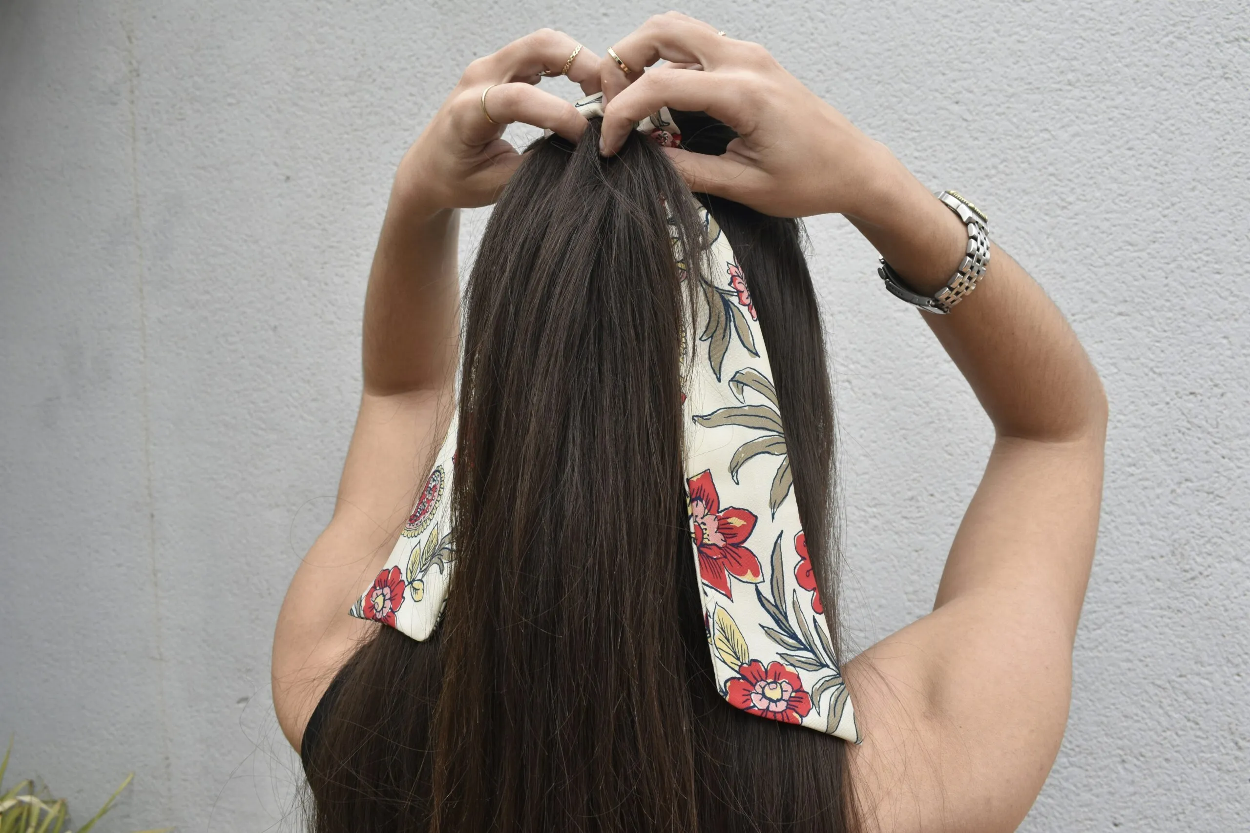 a woman with long hair is putting on a bandana