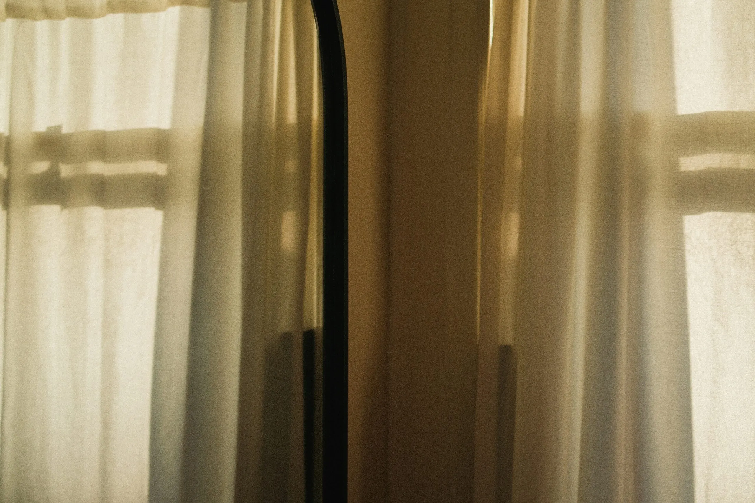 A room with curtains and a mirror in it