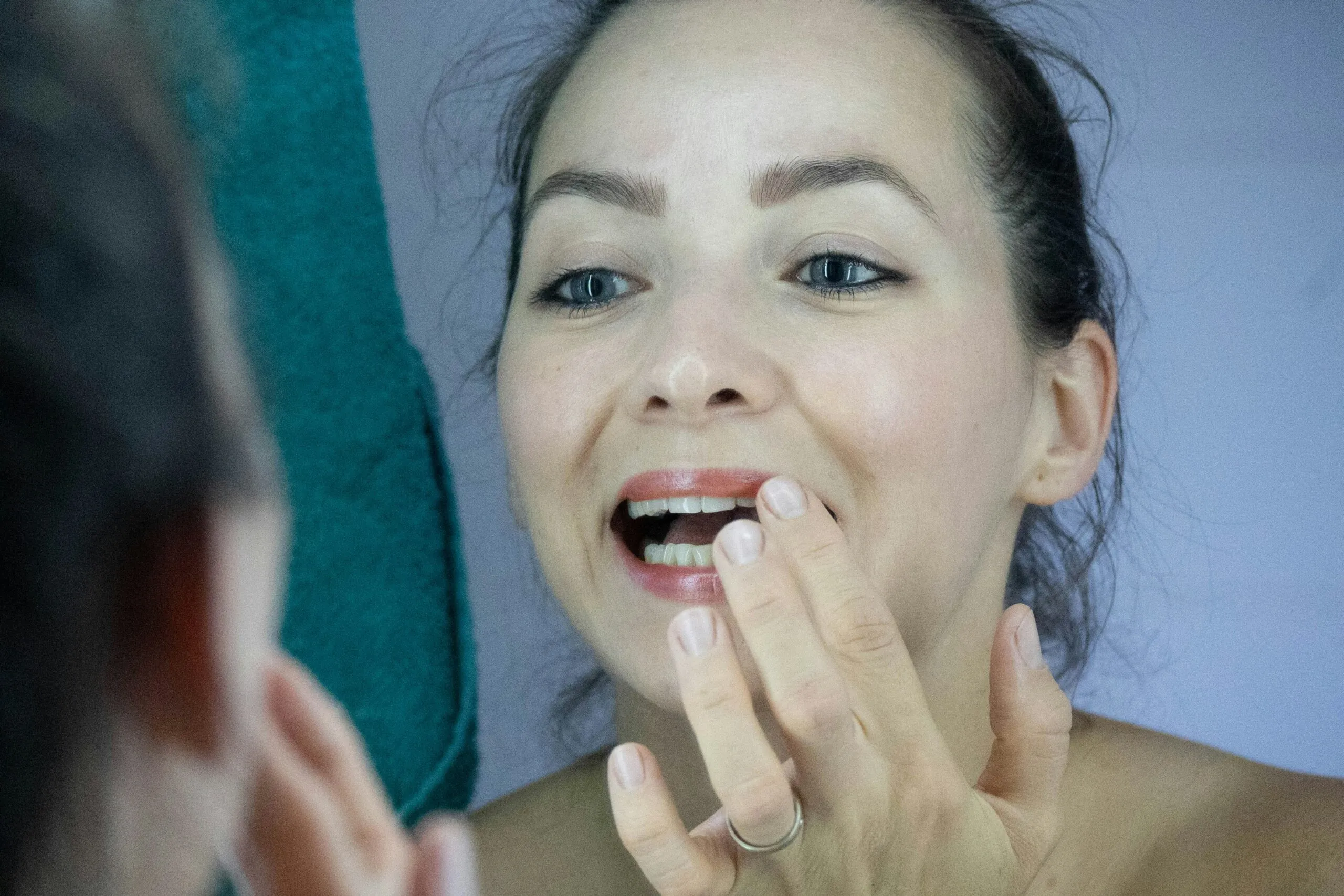 a woman brushing her teeth in front of a mirror