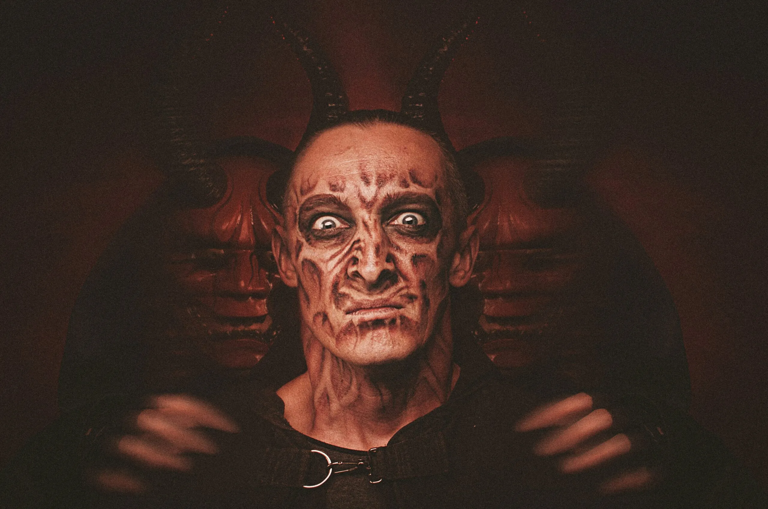 a man with a devilish face and horns on his head