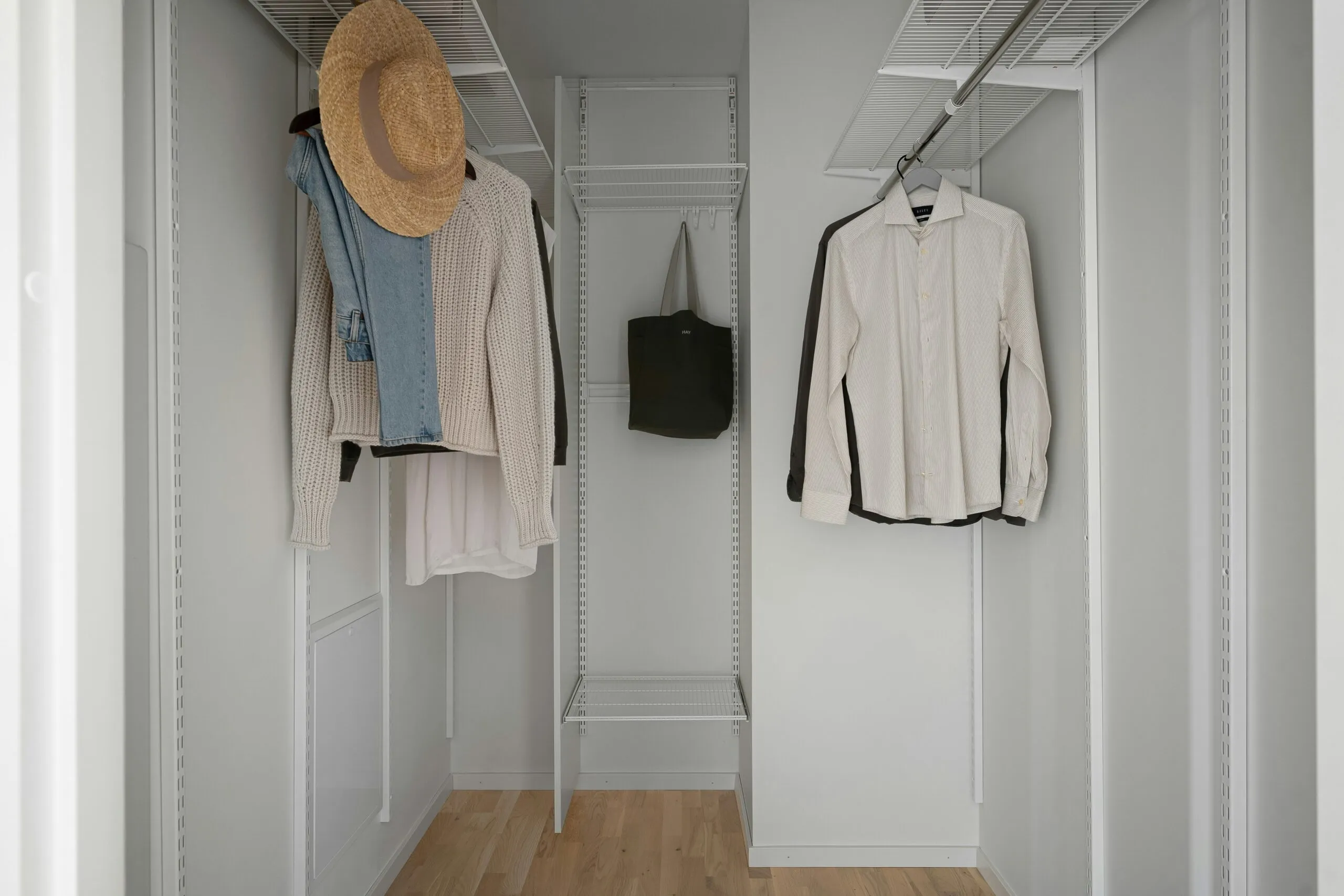 A white closet with a hat and coat rack