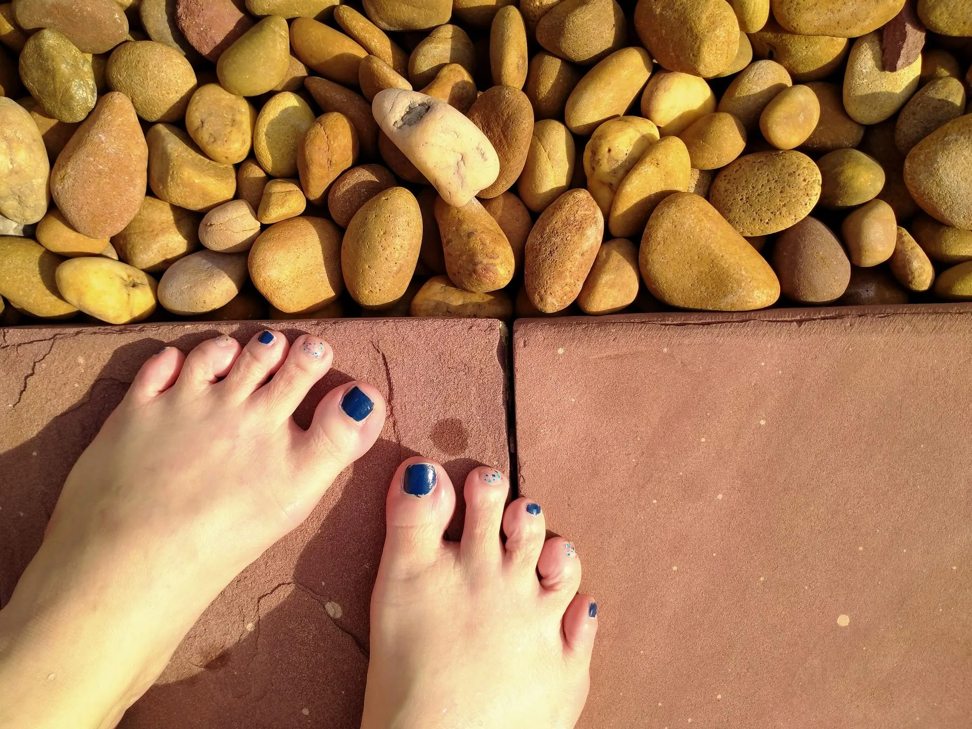 Low section of woman legs on pebbles