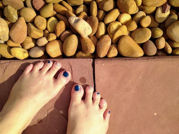 Low section of woman legs on pebbles