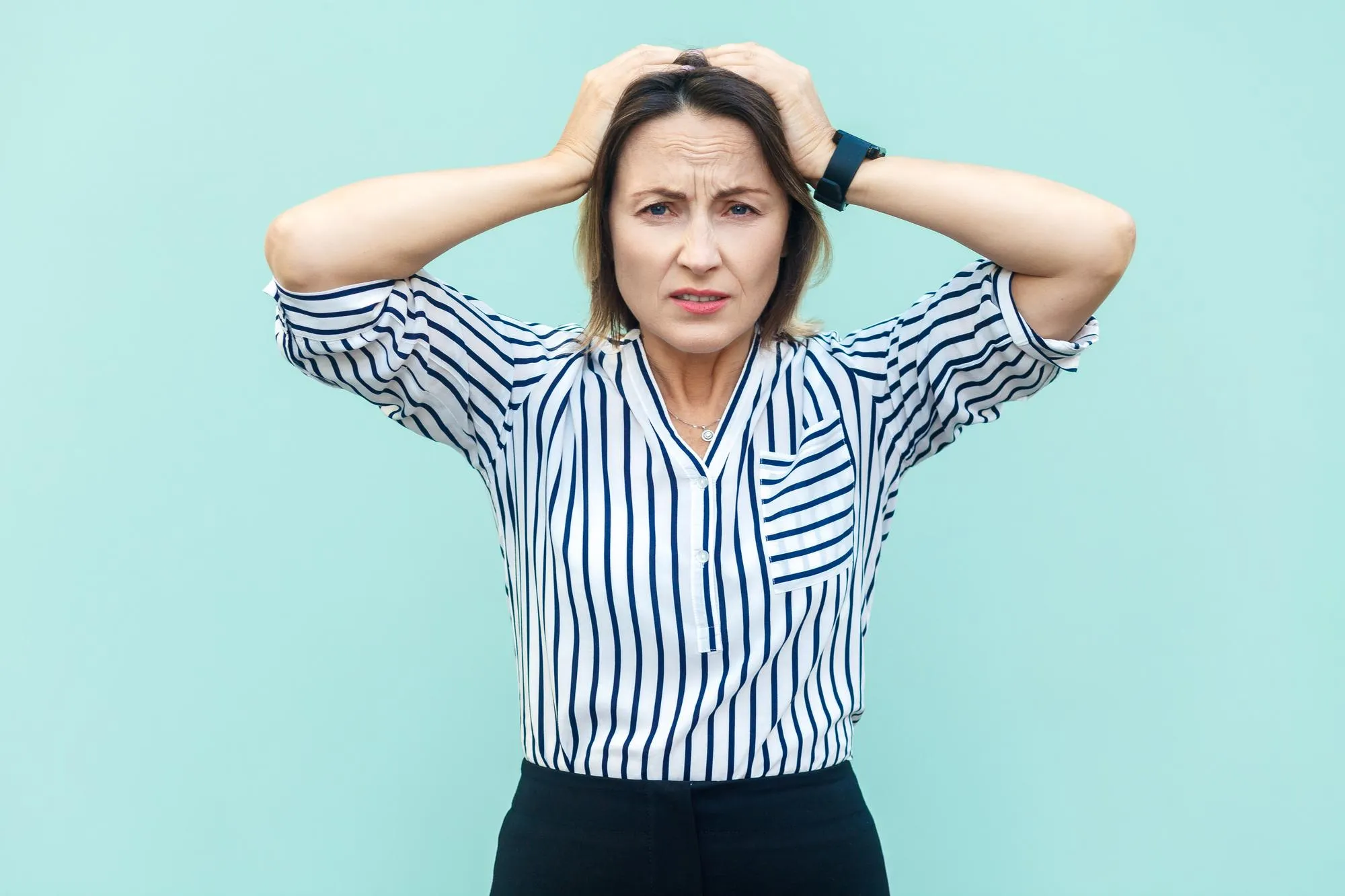 Portrait of young woman standing against blue background