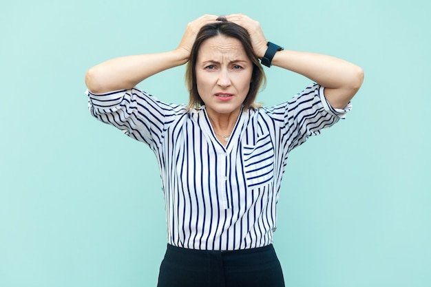 Portrait of young woman standing against blue background