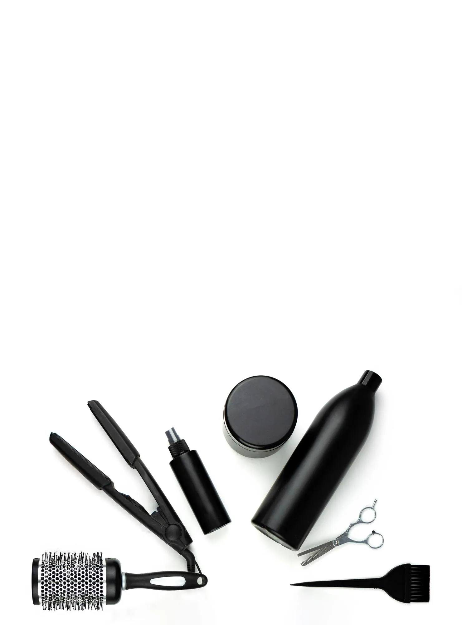 Professional items for a hairdressers on a white background Composition with scissors spray shampoo brush curling iron comb hair clipper other hairdresser's accessories on white background
