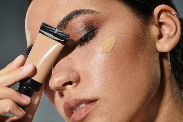Stylish woman applying foundation while preparing for a glamorous evening event indoors
