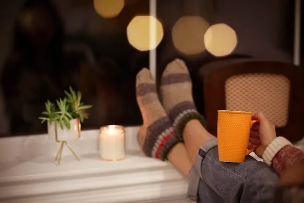Midsection of woman holding illuminated candles at home