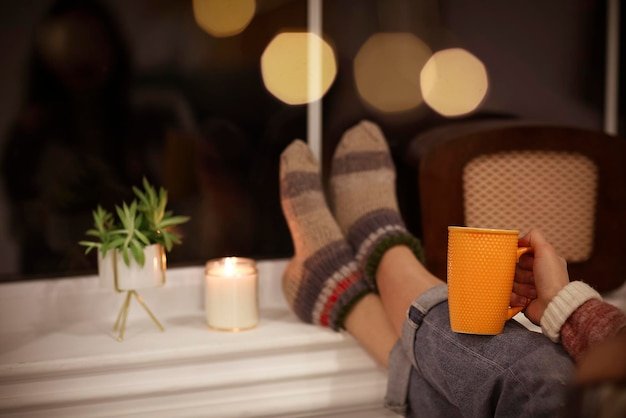 Midsection of woman holding illuminated candles at home
