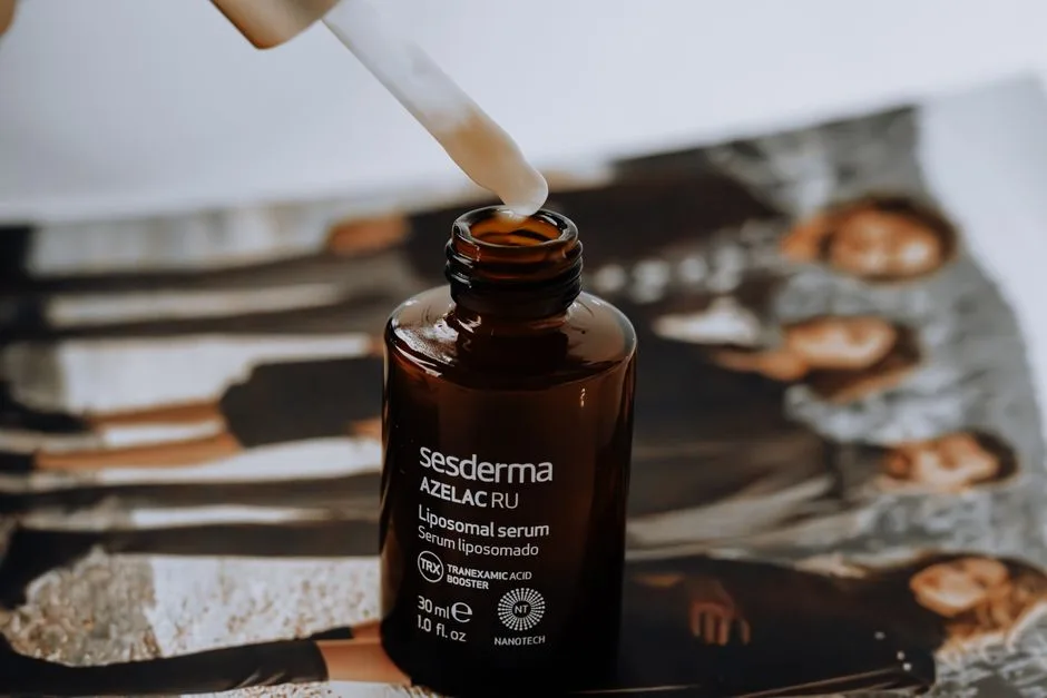 A liposomal serum bottle with a dropper placed on a magazine with blurred background.
