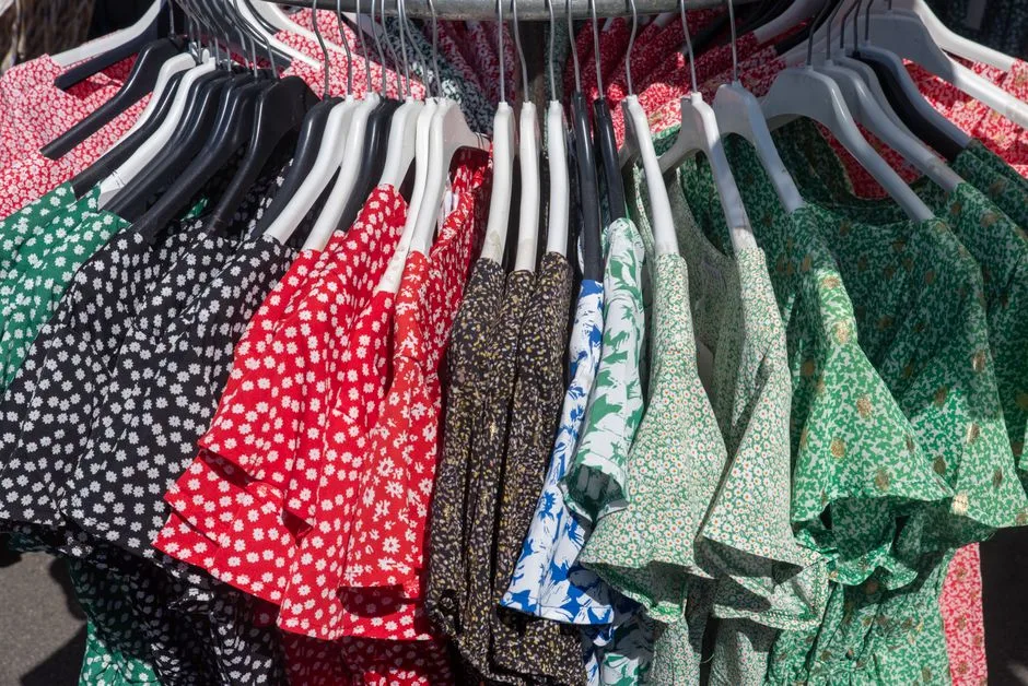 Vibrant collection of floral and patterned dresses hanging on a clothing rack, showcasing diverse styles.