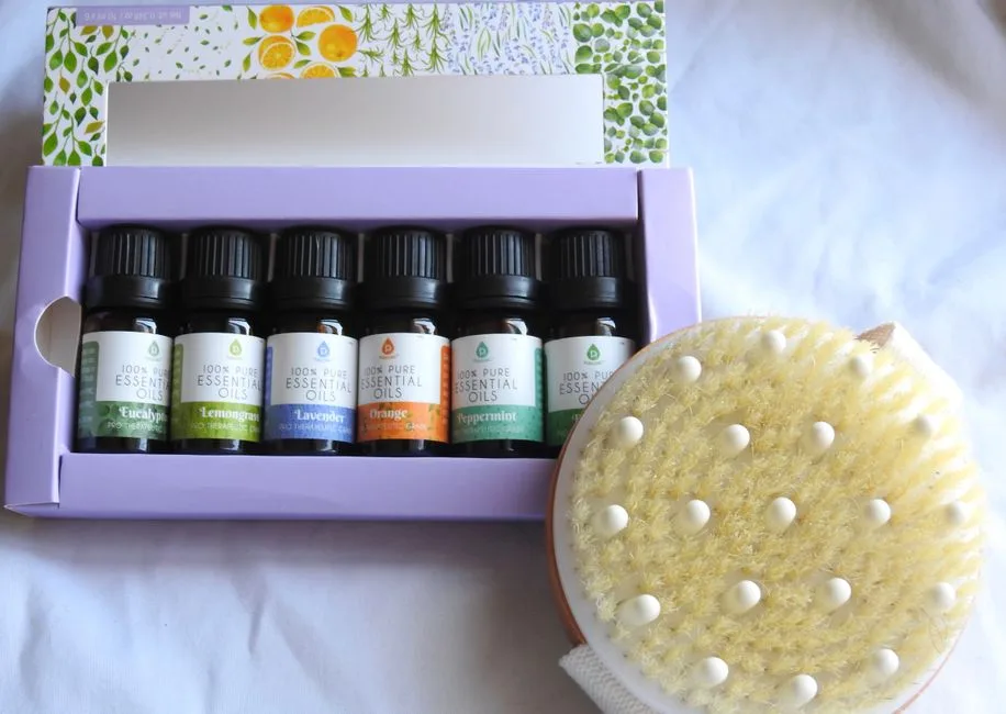 A selection of essential oils and a dry brush, perfect for a relaxing spa day at home.