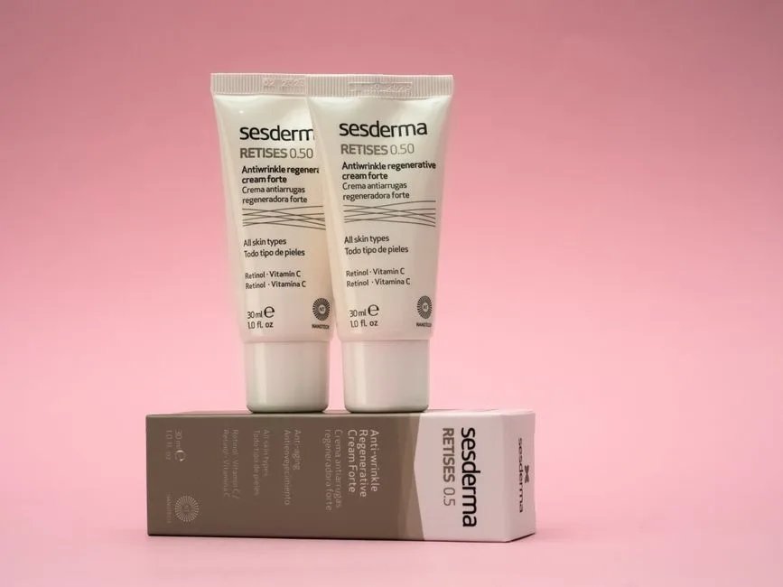 Two Sesderma Retises antiwrinkle creams on a pink background, emphasizing skincare.