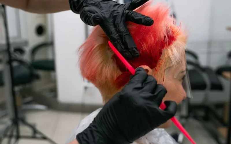 Close-up of a vibrant hair coloring process in a salon, showcasing expertise and trendy style.