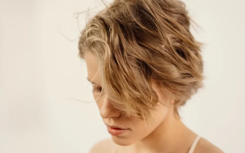 Artistic close-up of a young woman with stylish short hair indoors.