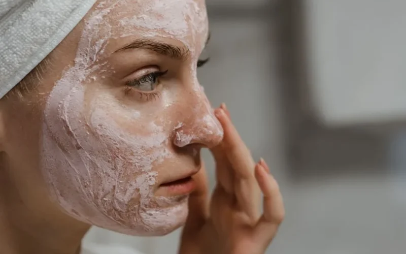 Close-up of a woman applying facial cream as part of her skincare routine, enhancing skin health.